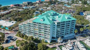 Un hôtel à plusieurs étages doté d’un toit végétalisé, situé près d’une marina où sont amarrés des bateaux.