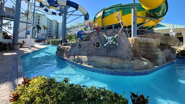 Parque acuático con piscina, toboganes y decoración temática de piratas.