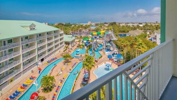 Un hotel con varias piscinas, parque acuático y vista al océano.
