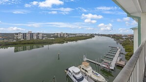 Ein Yachthafen mit vertäuten Booten, ein ruhiger Fluss und Gebäude im Hintergrund.