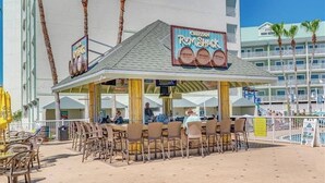 Eine Strandbar mit Sitzgelegenheiten im Freien und einem Schild, das Cruzan Rumshack bewirbt.