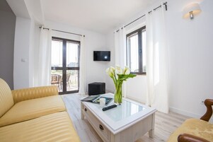 Suíte, 2 quartos, terraço | Área de estar | TV de tela plana