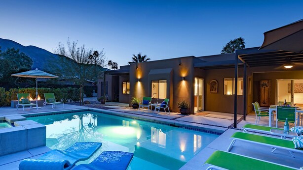 A modern pool area with lounge chairs and a well-lit patio. - San Lucas Hideout (Palm Springs)
