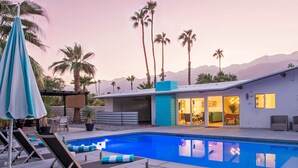 A modern house with a swimming pool, outdoor seating, and a patio area. - Alexander Sunrise (Palm Springs)