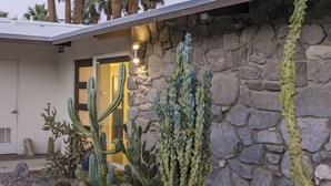 A desert garden with various cacti and a stone wall. - Alexander Sunrise (Palm Springs)