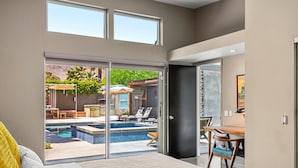 A bedroom with a large sliding glass door leading to a pool area. - Lucy I'm Home (Palm Springs)