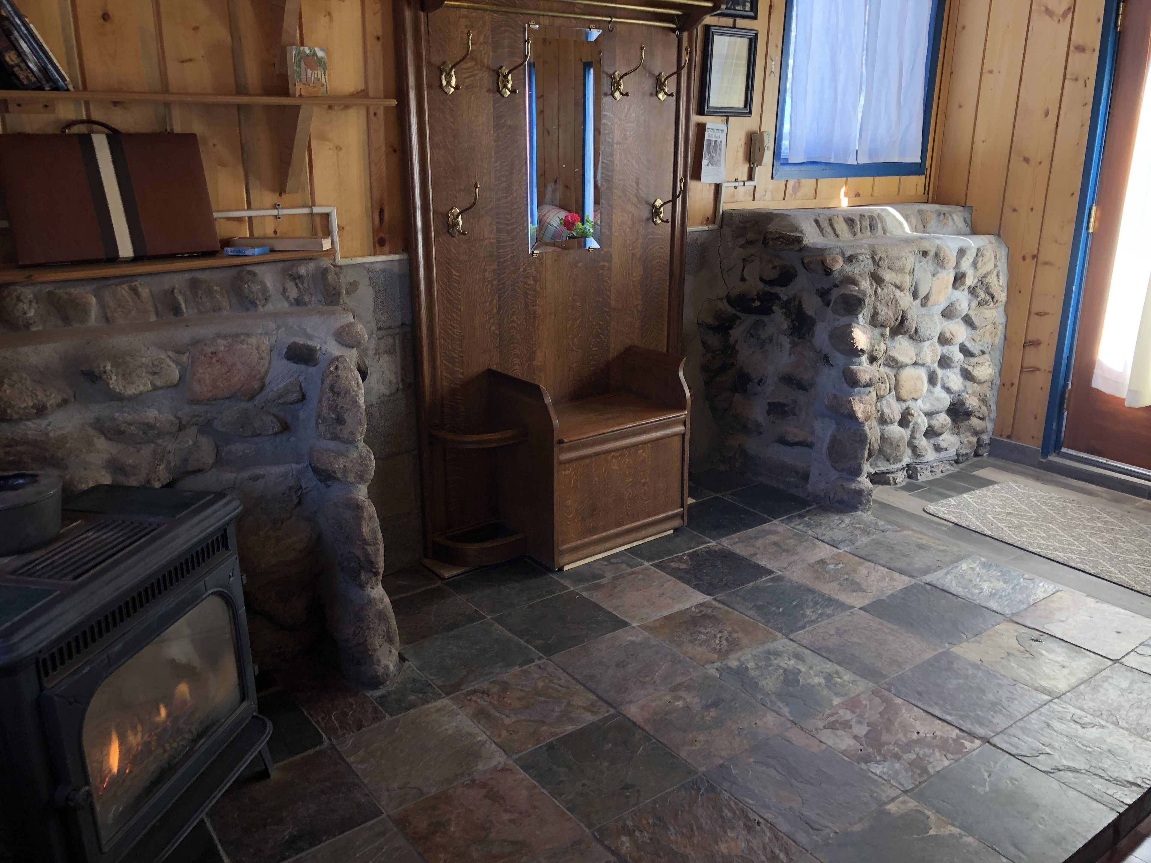 Una habitación acogedora con chimenea de piedra, estanterías de madera y pared de piedra.