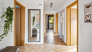 A hallway with wooden doors, a large mirror, and a poster on the wall.
