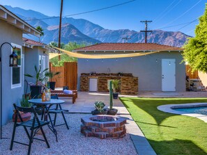 A backyard with a barbecue area, outdoor seating, and a swimming pool. - Boho Rhapsody (Palm Springs)