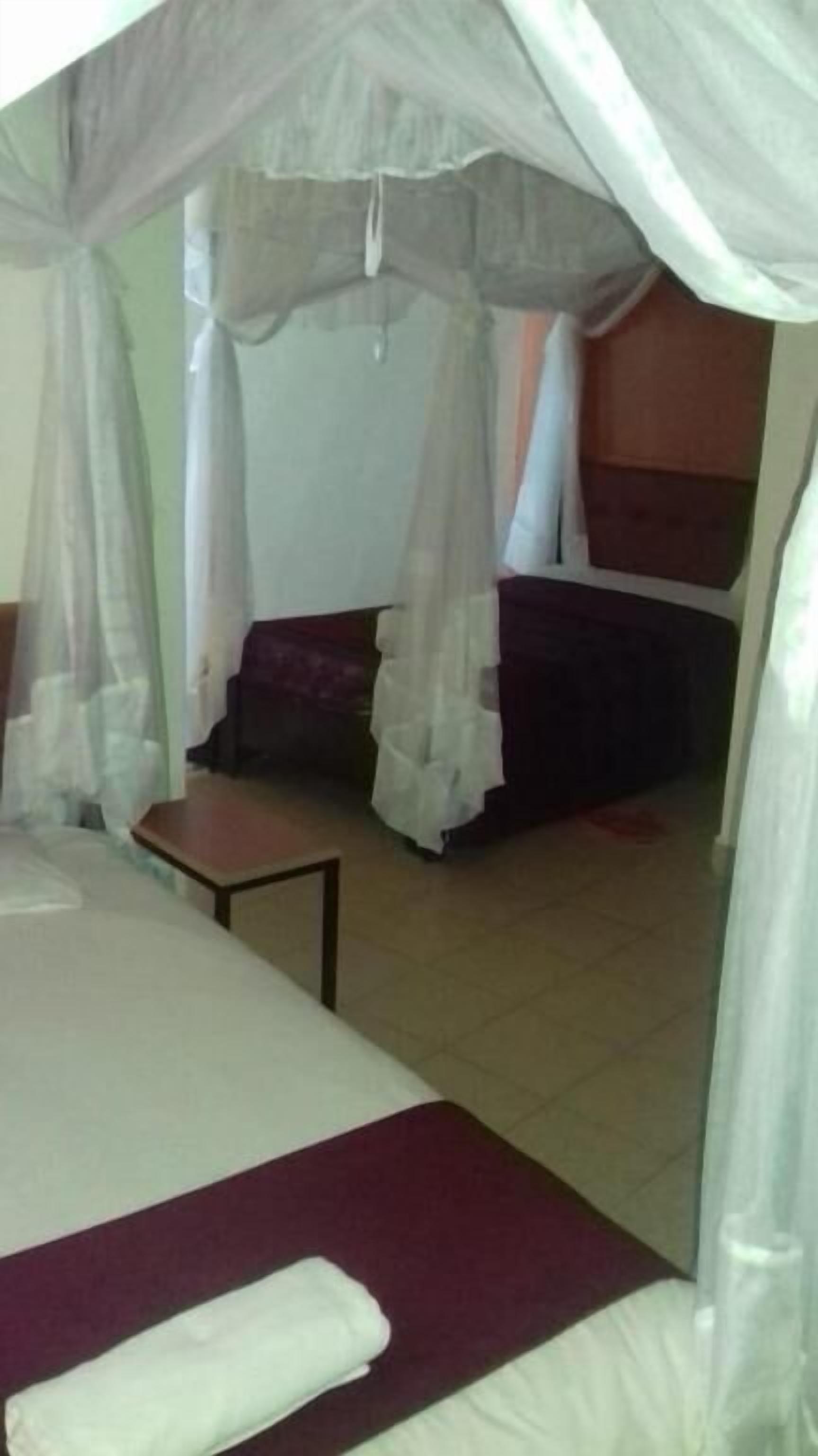 A room with a bed, a small table, and a bench.