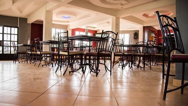 A spacious dining area with high ceilings and modern chairs. - Lila Hotel (Kisumu)