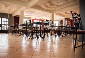 A spacious dining area with high ceilings and modern chairs.
