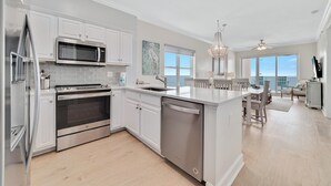 Een moderne keuken met witte kasten, roestvrijstalen apparatuur en een centraal eiland.