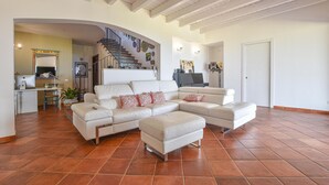 A spacious living room with a large L-shaped sofa, a flat-screen TV, and a staircase leading to an upper floor. - Luxurious home in Partinico (PA) (Partinico (PA))