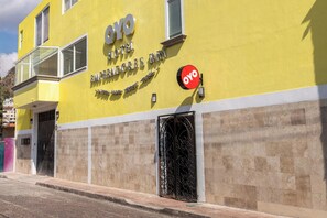 A yellow building with a sign for the OYO Hotel Emmerendores Inn. - Capital O Hotel Emperadores Inn, Atlixco (Atlixco)
