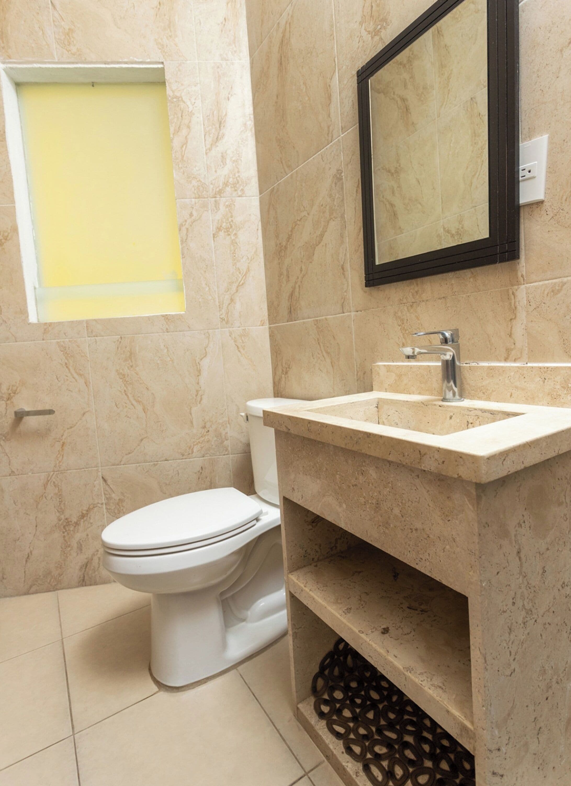 Ein Badezimmer mit Toilette, Waschbecken und Spiegel.
