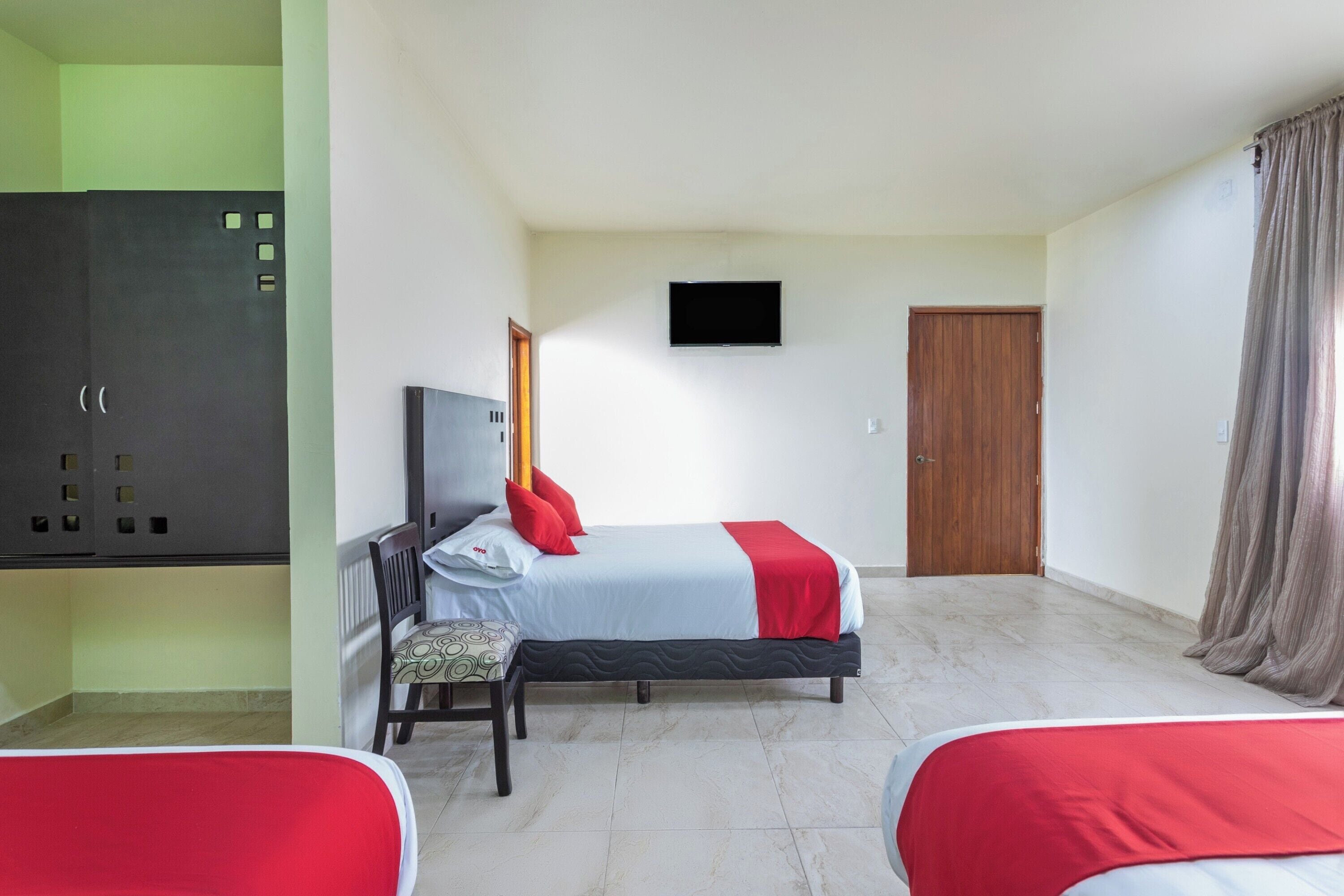 Une chambre d’hôtel équipée d’un lit, d’un bureau, d’une chaise, d’une télévision et d’une armoire.