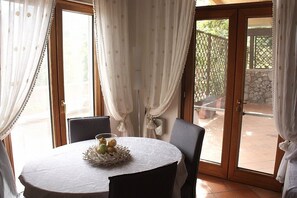 A round table with a white tablecloth and a centerpiece of fruits and a decorative bowl.