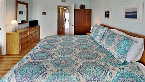 Une chambre à coucher avec un grand lit, une commode en bois et une armoire.