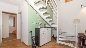 A modern interior with a staircase, a small desk with drawers, a trash bin, and a chair. - Amazing home in Klenovica (Klenovica)