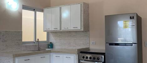 Een koelkast, een oven, een kookplaat, een koffiezetapparaat/waterkoker