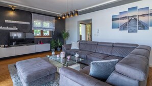 A modern living room with a grey sectional sofa, a glass coffee table, and a flat-screen TV. - Pet friendly home in Vodnjan (Vodnjan)