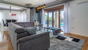 A modern living room with a grey sectional sofa, a glass coffee table, and a black and white rug. - Pet friendly home in Vodnjan (Vodnjan)