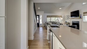 A modern kitchen with a large island, a dining area with a sofa, and a fireplace.