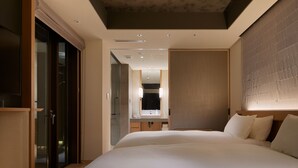 A modern hotel room with a large bed, a walk-in closet, a bathroom with a mirror and sink, and a ceiling with recessed lighting. - Agora Tokyo Ginza (Tokyo)
