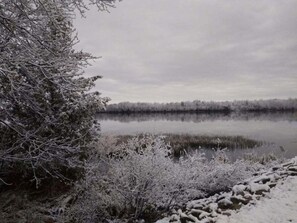 Surrounded by snow-covered trees, this serene lake offers a tranquil atmosphere.