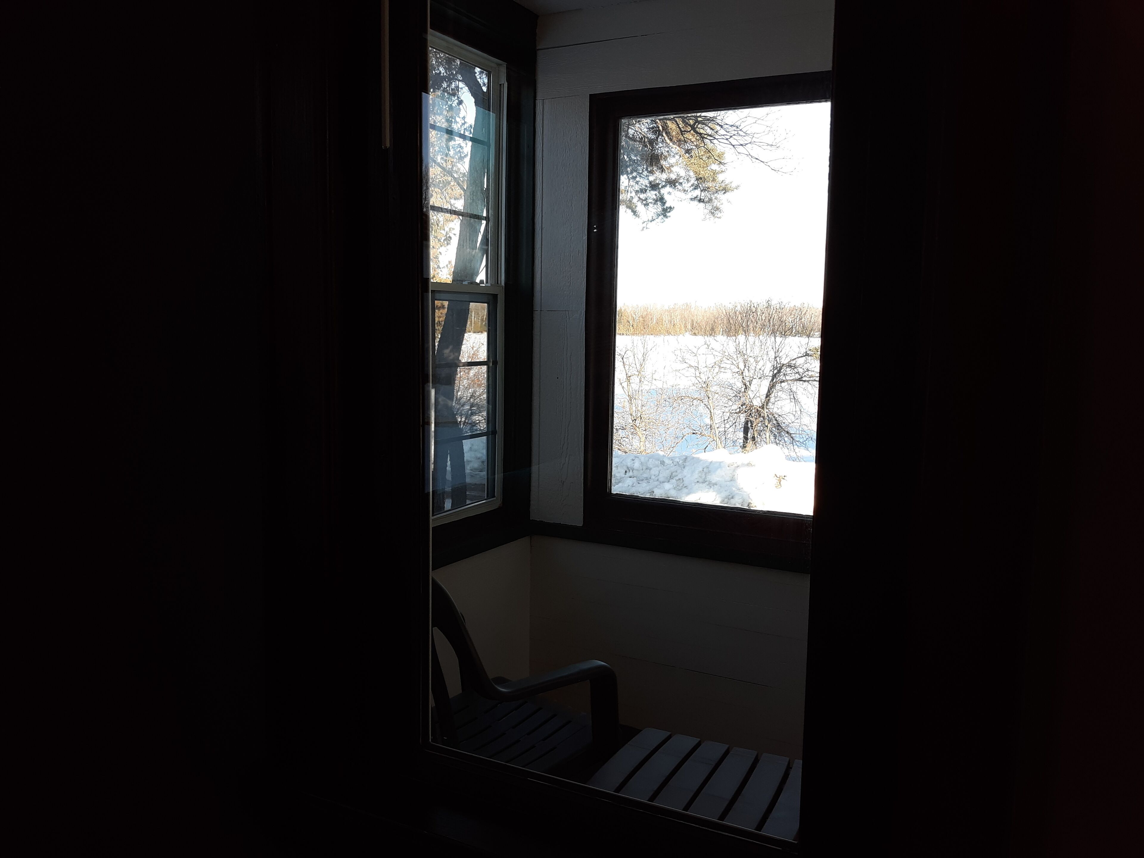Une pièce avec une fenêtre donnant sur un paysage enneigé.