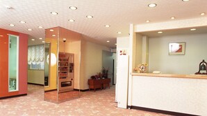 Ein Hotel-Empfangsbereich mit einer Theke, einem Automaten und einer Rezeption.