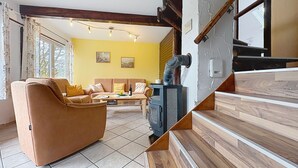 A living room with a sofa, a coffee table, and a fireplace. - Am Sternberg 38 by Interhome (Frankenau)