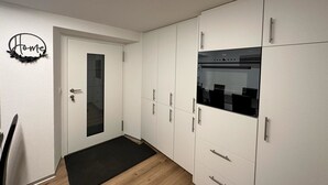 Een moderne keuken met witte kasten, een zwart aanrecht en een ingebouwde oven.