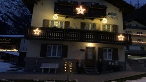 A two-story building with balconies, star-shaped lights, and a sign reading "ENZIAN".