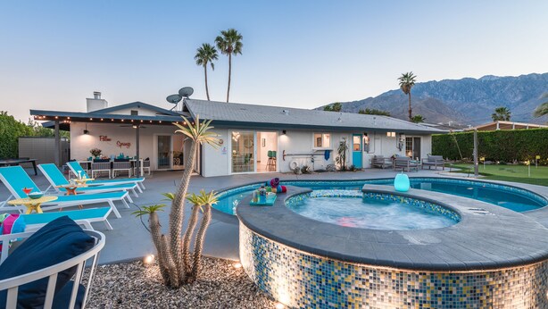 A modern house with a swimming pool and lounge chairs.