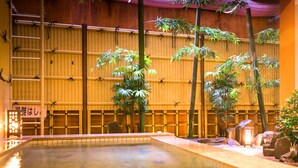 An indoor pool with bamboo walls and a small waterfall feature. - Dogo Grand Hotel (Matsuyama)