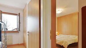 A bedroom with a bed, a radiator, and a window. - Condominio al Parco by Interhome (Canazei)