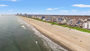 Eine Küstenstadt mit Sandstrand und direkt am Strand gelegenen Häusern.