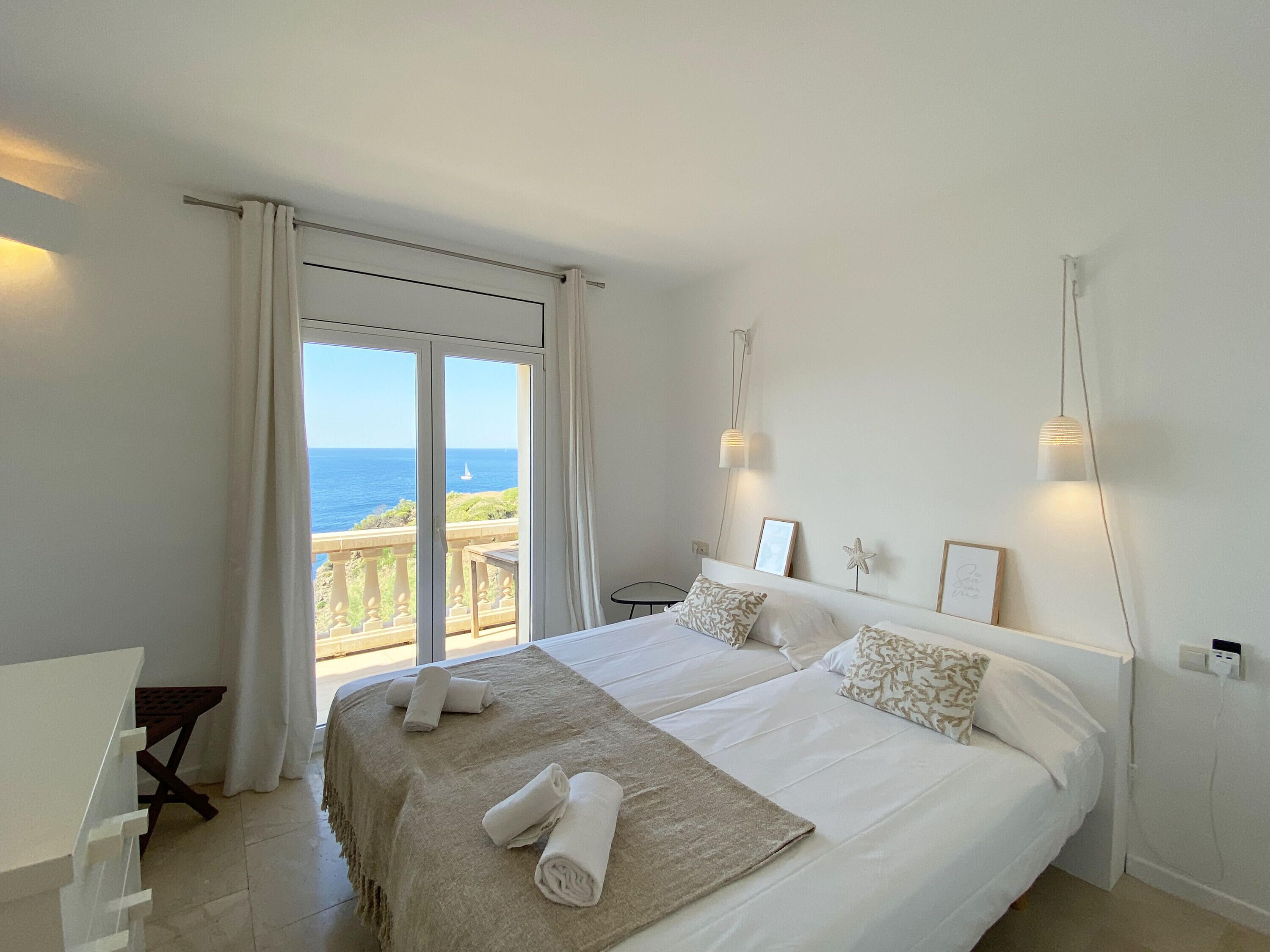 Une chambre avec un grand lit, une vue sur la mer et un balcon.