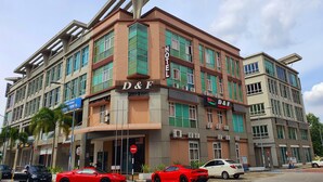 A hotel with a prominent D&F sign, multiple floors, and a modern architectural design.