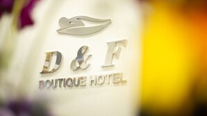 A logo with the letters "D&F" and the words "BOUTIQUE HOTEL" on a wall.
