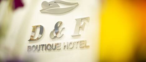 A logo with the letters "D&F" and the words "BOUTIQUE HOTEL" on a wall.