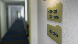 A hotel corridor with directional signs indicating room numbers. - Hotel Stay Inn Köln Leverkusen City (Leverkusen)