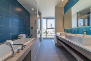 A modern bathroom with two sinks, a large bathtub, and a glass shower enclosure. - Holiday Inn Express Kaifeng City Center by IHG (Kaifeng)