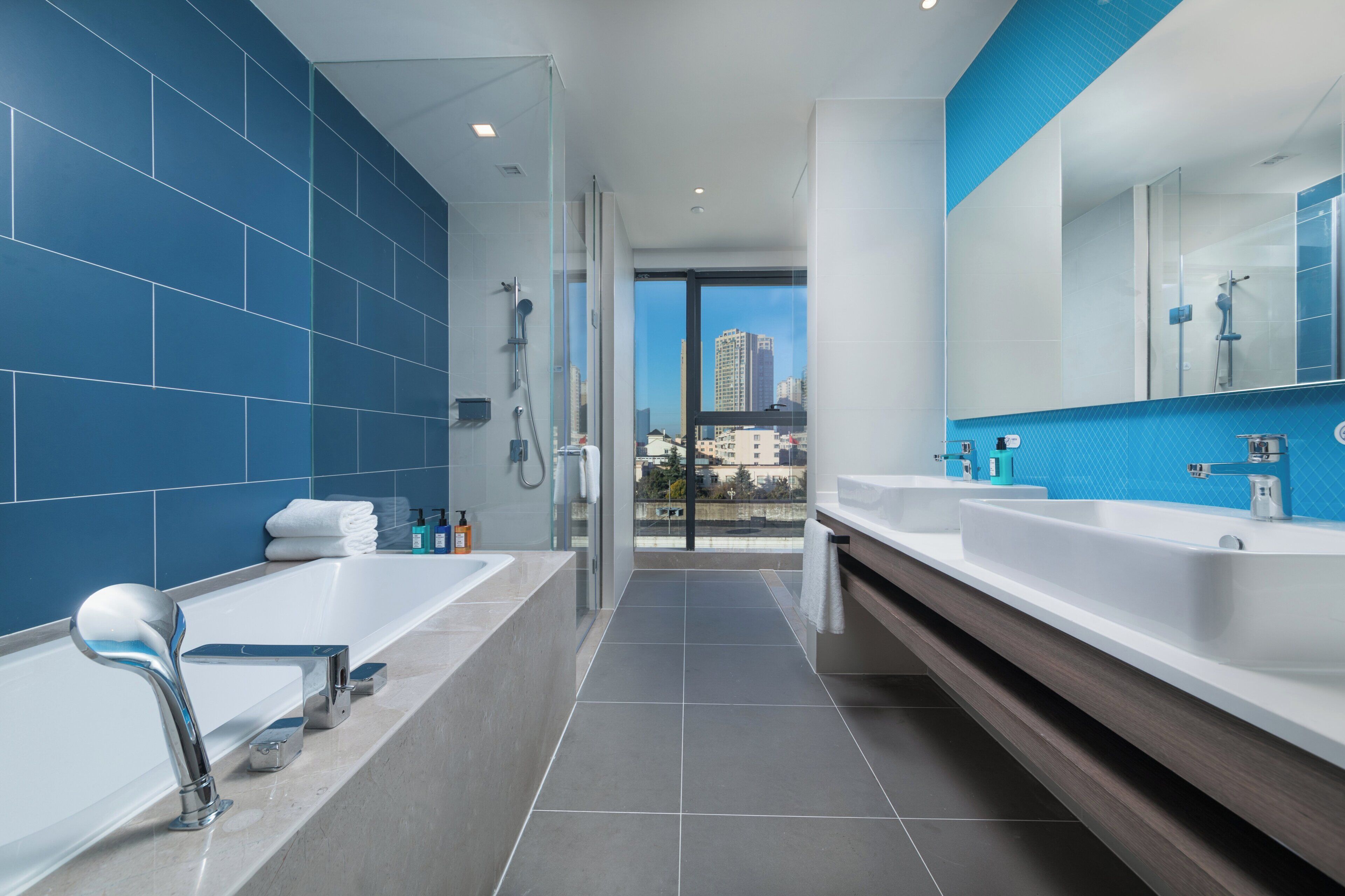 Un baño moderno con una bañera grande, ducha y tocador con espejo.