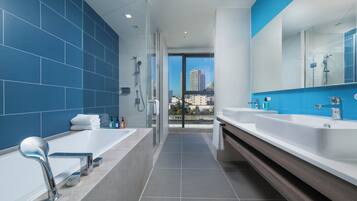 Un baño moderno con una bañera grande, ducha y tocador con espejo.