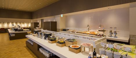 Un espace buffet proposant différents stands de restauration, avec notamment des salades, des plats de viande et des boissons.