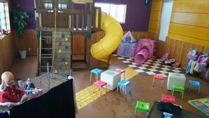 A children's play area with a slide, climbing wall, and various play structures. - Alpine Lodge (Hakuba)