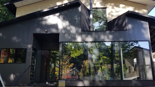 A modern building with large windows, a flat roof, and a visible chimney. - Alpine Lodge (Hakuba)
